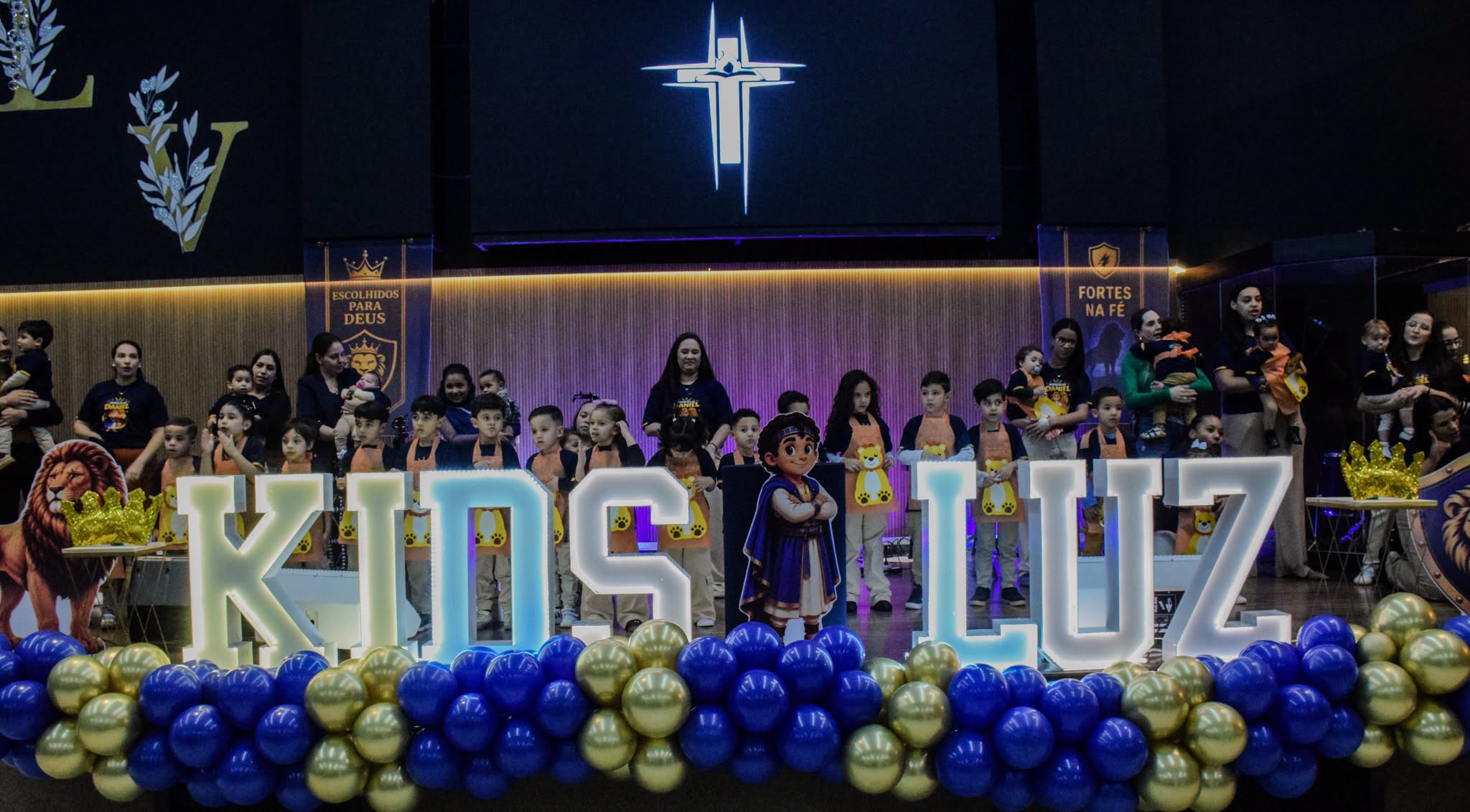 Crianças e famílias participando de uma celebração do Luz Kids